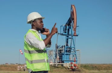 engenheiro-negro-fala-ao-telefone-com-colega-perto-de-jackpump_255755-8416